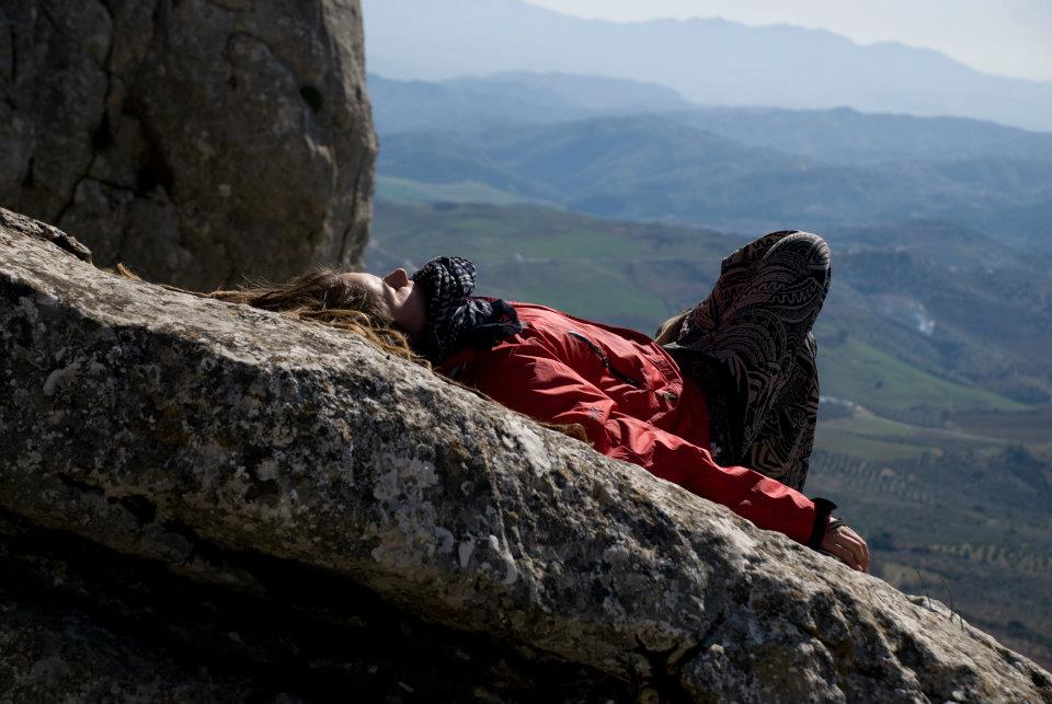 Девушка лежит на скале смотрит на солнце